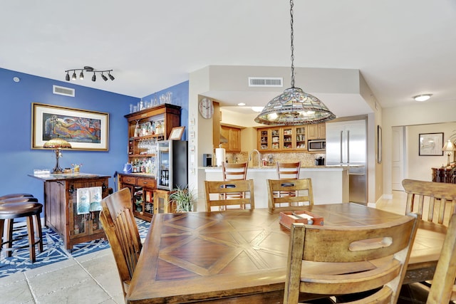 dining area featuring rail lighting and visible vents