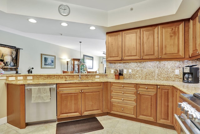 kitchen featuring decorative backsplash, appliances with stainless steel finishes, light stone counters, a peninsula, and a sink