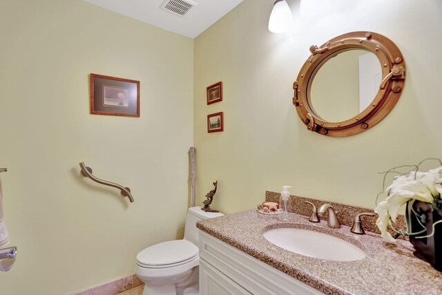 bathroom with tile patterned flooring, vanity, and toilet