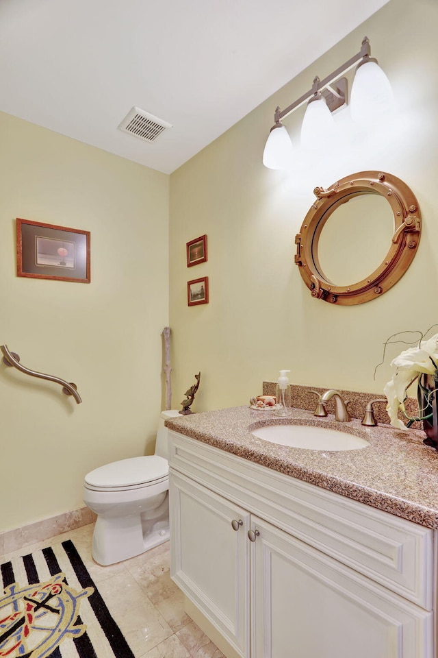 half bathroom featuring visible vents, vanity, and toilet