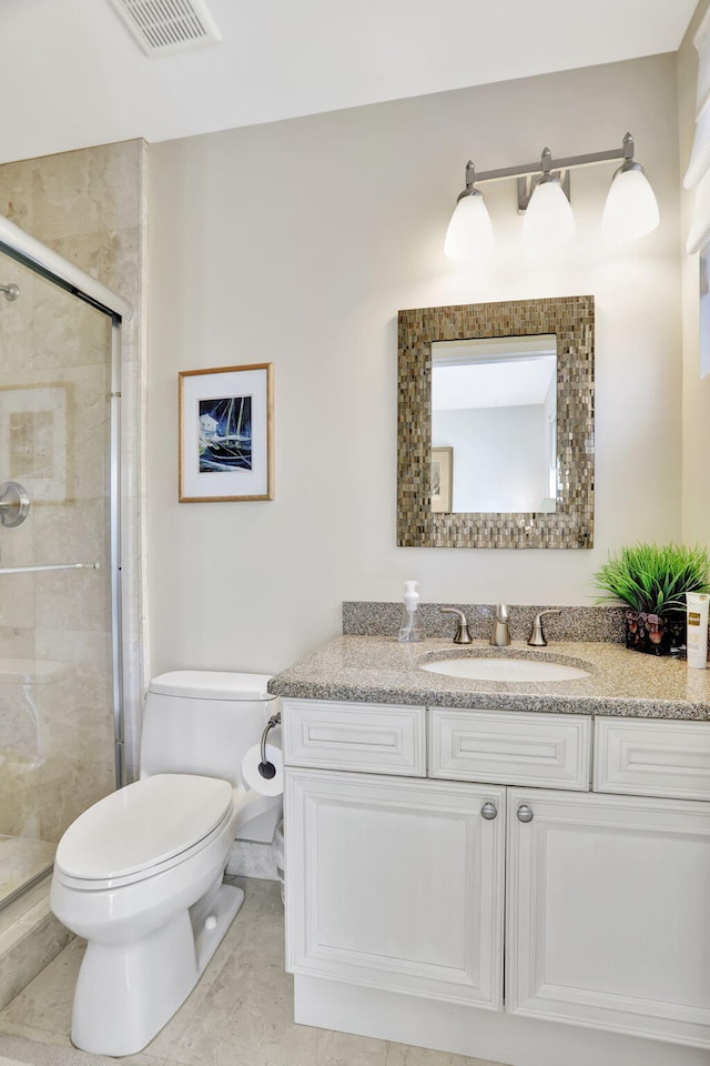 bathroom with tile patterned flooring, toilet, vanity, and walk in shower