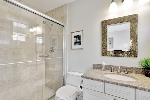 bathroom featuring a stall shower, vanity, and toilet