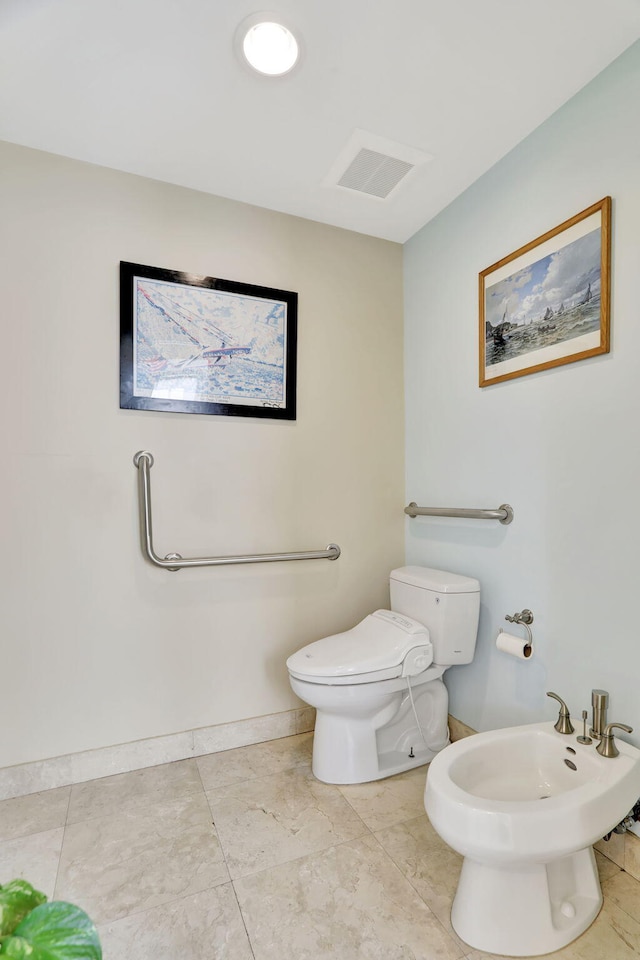 bathroom featuring baseboards, a bidet, visible vents, and toilet