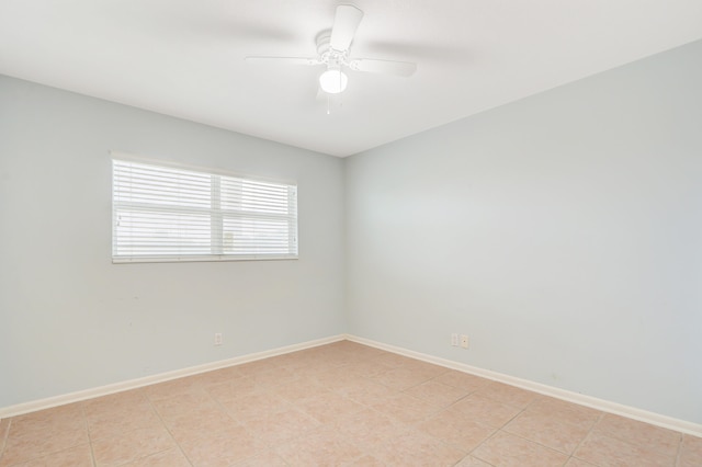 empty room with ceiling fan and light tile patterned flooring