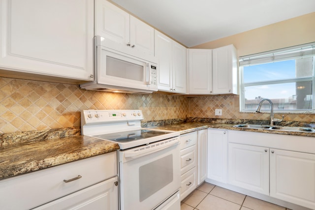 kitchen with white cabinetry, sink, light tile patterned flooring, and white appliances