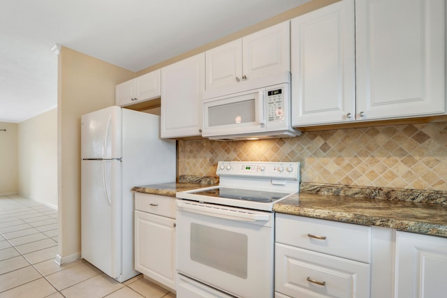 kitchen with decorative backsplash, dark stone counters, white appliances, light tile patterned floors, and white cabinets