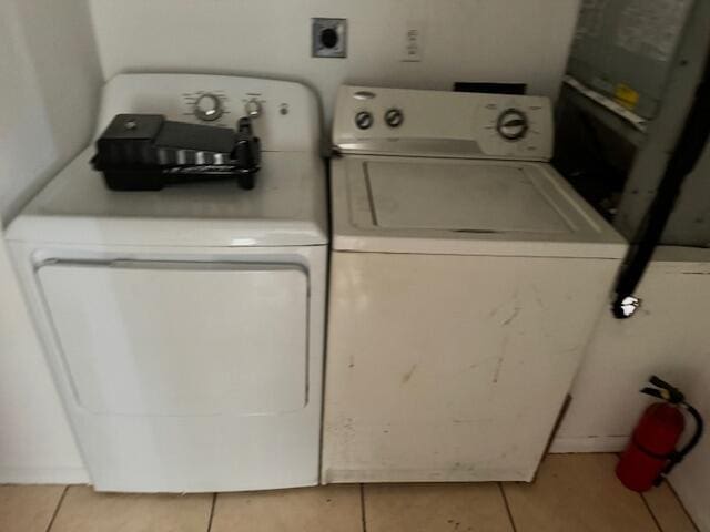 laundry area with washer and dryer and light tile floors