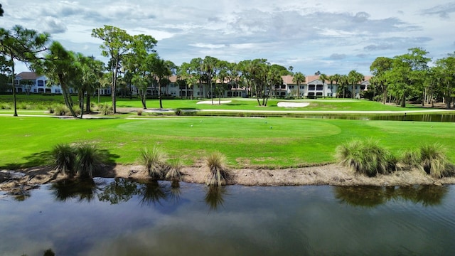 view of home's community with a water view and a lawn