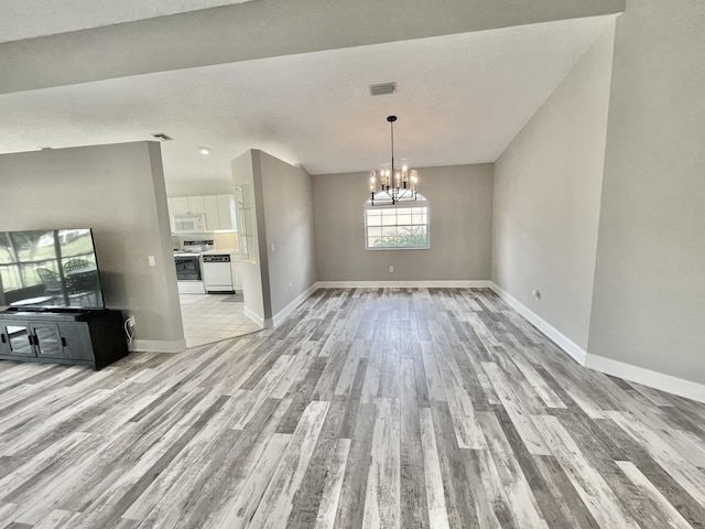 unfurnished dining area featuring a notable chandelier and light hardwood / wood-style floors