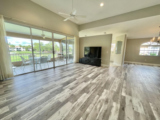 unfurnished living room featuring light hardwood / wood-style floors and ceiling fan with notable chandelier