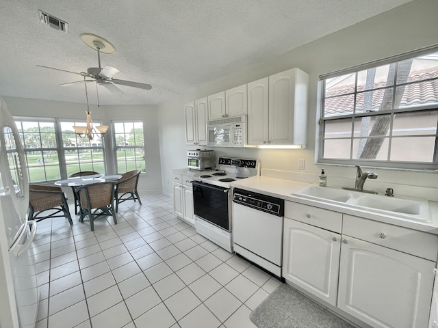 kitchen featuring white appliances, sink, a textured ceiling, light tile patterned flooring, and white cabinetry