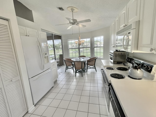 kitchen featuring a textured ceiling, white cabinetry, light tile patterned floors, and white appliances