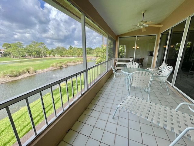 sunroom / solarium with a water view, ceiling fan, and lofted ceiling