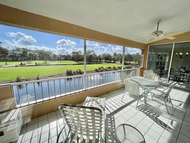 sunroom / solarium with a water view, plenty of natural light, and ceiling fan