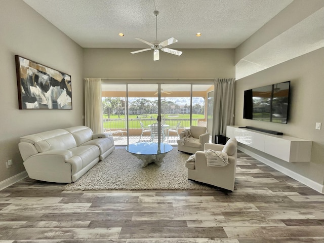 living room with hardwood / wood-style floors, a textured ceiling, and ceiling fan