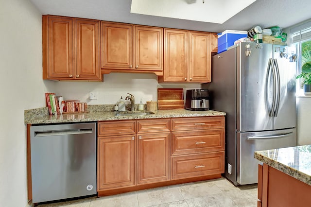 kitchen with light stone counters, sink, and stainless steel appliances