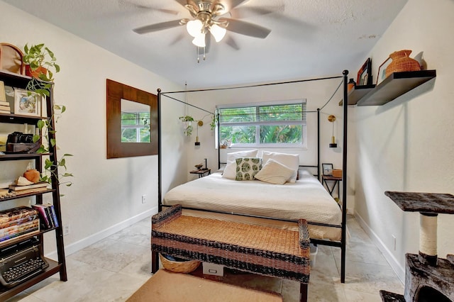 bedroom with ceiling fan and a textured ceiling