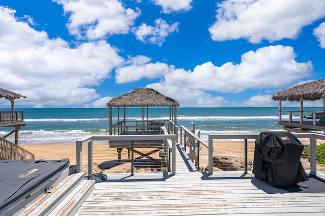 dock area featuring a beach view, a water view, and a gazebo