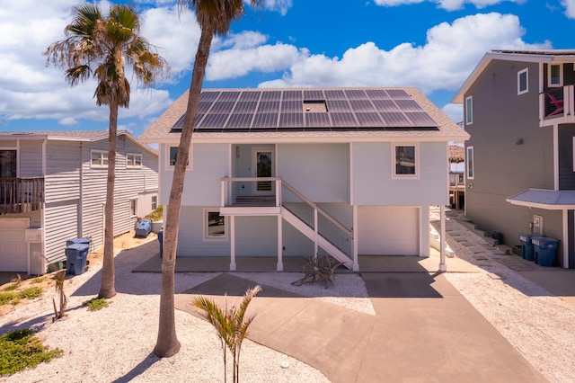 back of property featuring a garage and solar panels