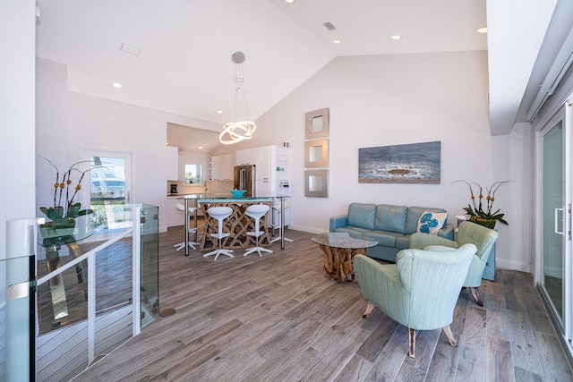 living room with high vaulted ceiling and hardwood / wood-style floors