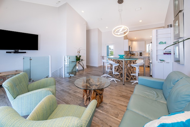 living room featuring high vaulted ceiling and light wood-type flooring