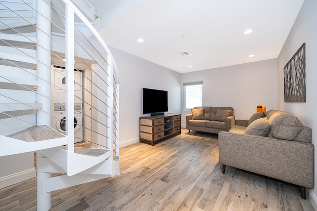 living room featuring stacked washer and dryer and hardwood / wood-style floors