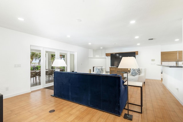 living area with recessed lighting, visible vents, and light wood-style floors