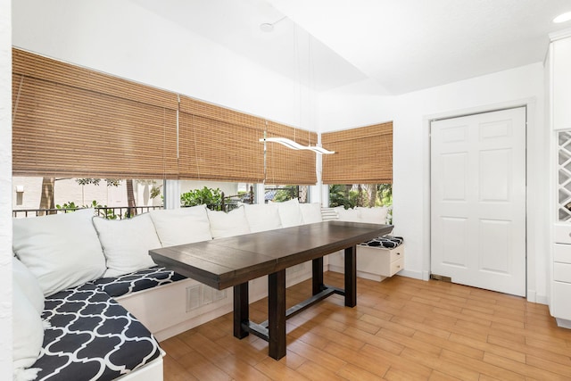 dining area with light wood-type flooring and visible vents