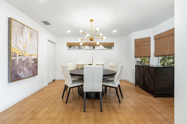 dining space featuring light wood-type flooring, an inviting chandelier, baseboards, and recessed lighting