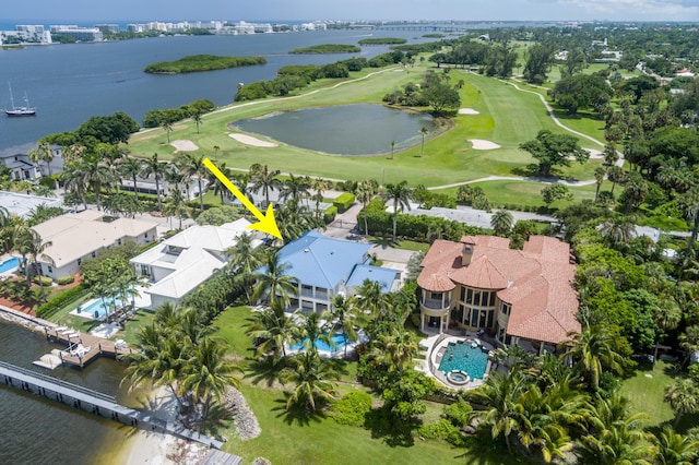 drone / aerial view featuring a residential view, view of golf course, and a water view