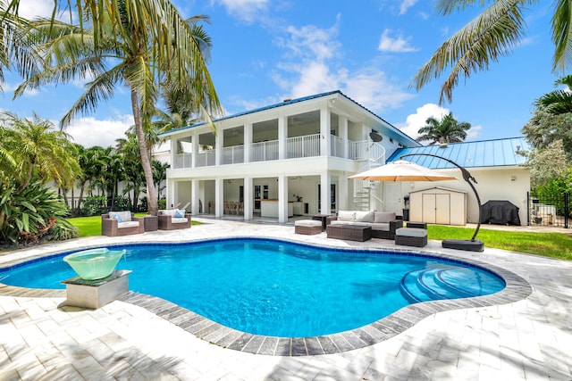 pool with a patio area, a storage shed, and an outdoor hangout area