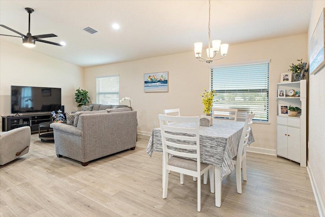 dining room featuring ceiling fan with notable chandelier and light hardwood / wood-style floors