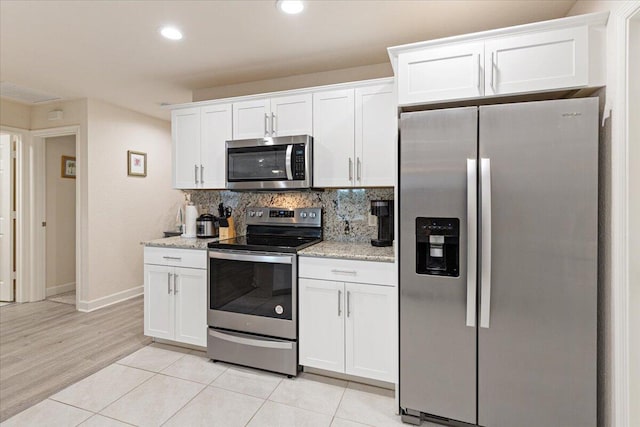 kitchen featuring white cabinets, appliances with stainless steel finishes, and backsplash