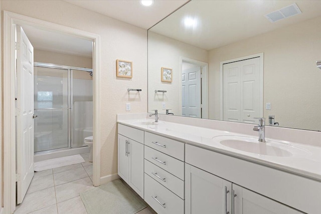 bathroom with tile patterned floors, vanity, toilet, and walk in shower