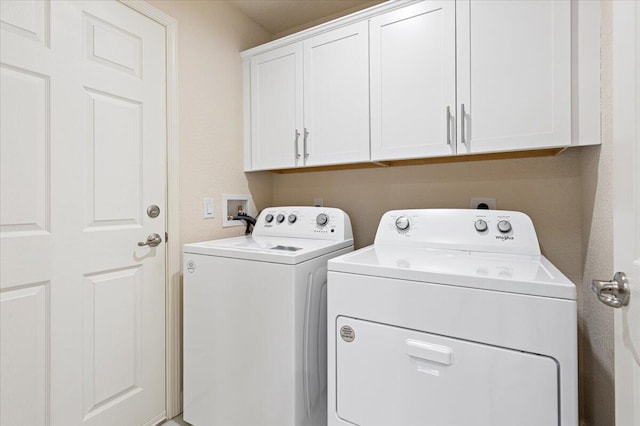 laundry room with washing machine and clothes dryer and cabinets