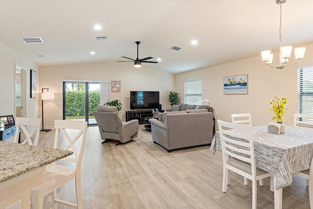 living room with ceiling fan with notable chandelier, light hardwood / wood-style floors, and lofted ceiling