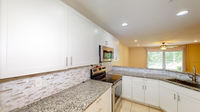 kitchen featuring light stone countertops, sink, white cabinets, and appliances with stainless steel finishes