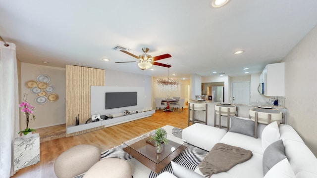 living room featuring ceiling fan and light hardwood / wood-style floors