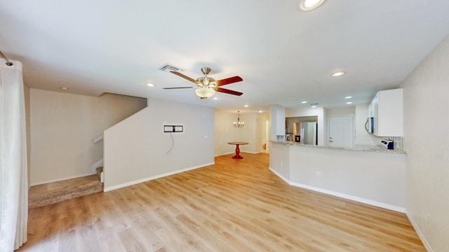 unfurnished living room featuring ceiling fan and light hardwood / wood-style floors