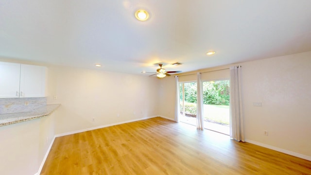 unfurnished living room with ceiling fan and light wood-type flooring