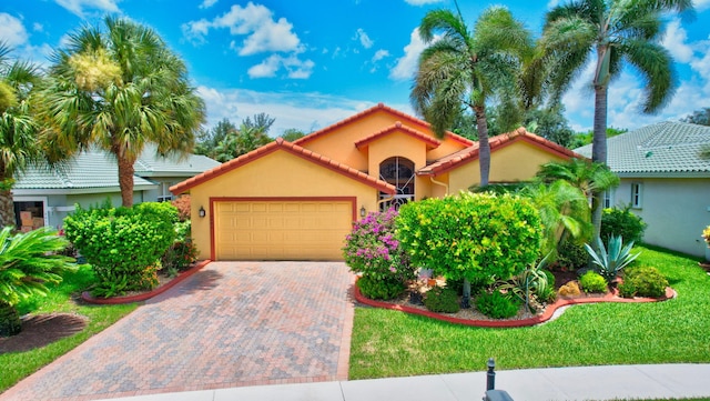 mediterranean / spanish home with a front yard and a garage