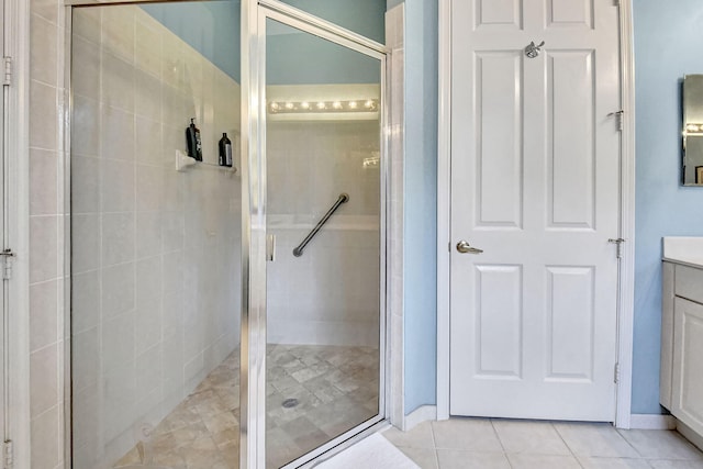 bathroom featuring a shower with door, tile patterned flooring, and vanity