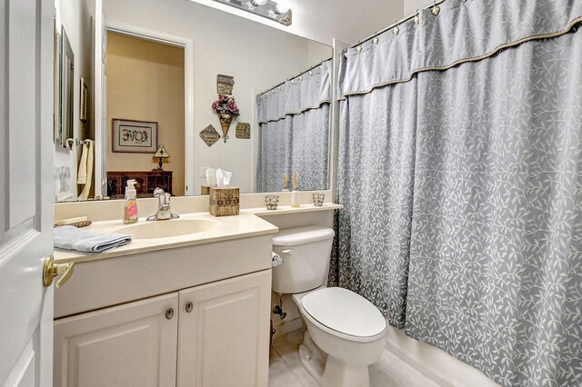 bathroom featuring vanity, curtained shower, and toilet