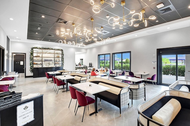 dining space featuring a paneled ceiling, a high ceiling, a healthy amount of sunlight, and a tray ceiling