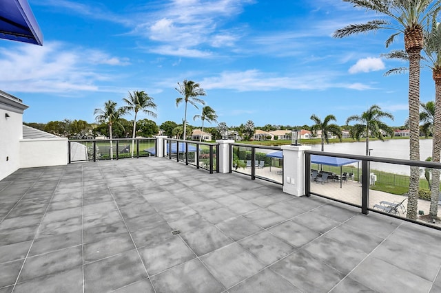 view of patio with a balcony and a water view