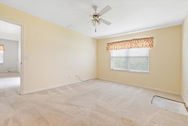 carpeted spare room featuring a textured ceiling and ceiling fan