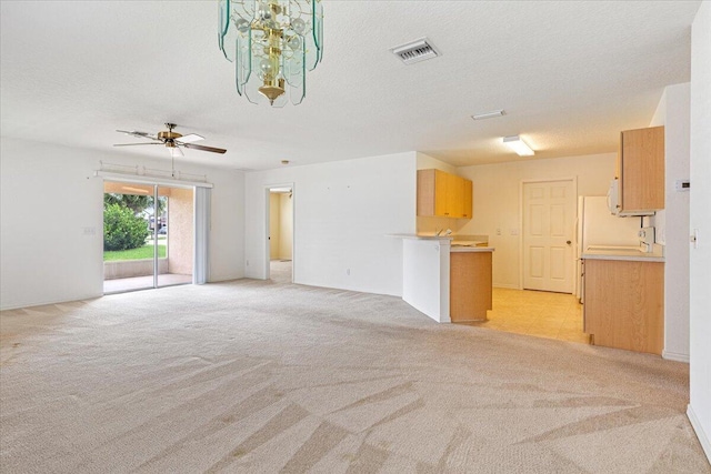 unfurnished living room featuring ceiling fan, light carpet, and a textured ceiling