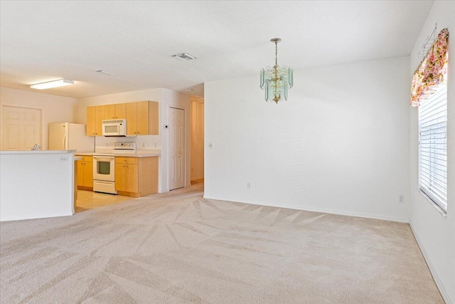 kitchen with a chandelier, light brown cabinets, white appliances, light carpet, and a textured ceiling