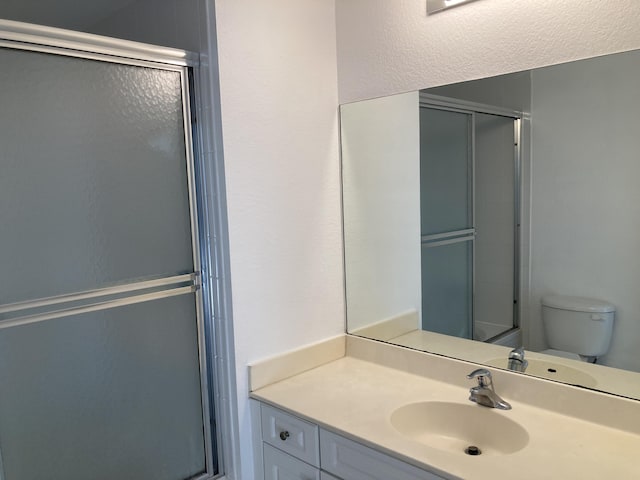 bathroom with toilet, walk in shower, and vanity