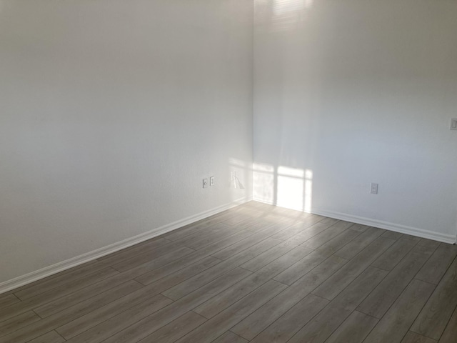 unfurnished room with dark hardwood / wood-style flooring